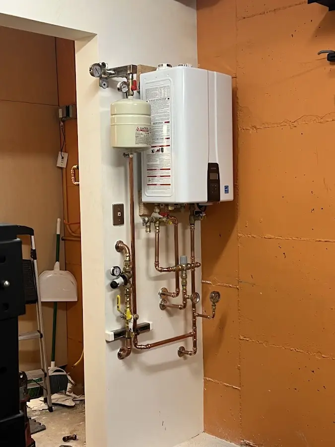Plumbing technician inspecting water heater connections in Brea